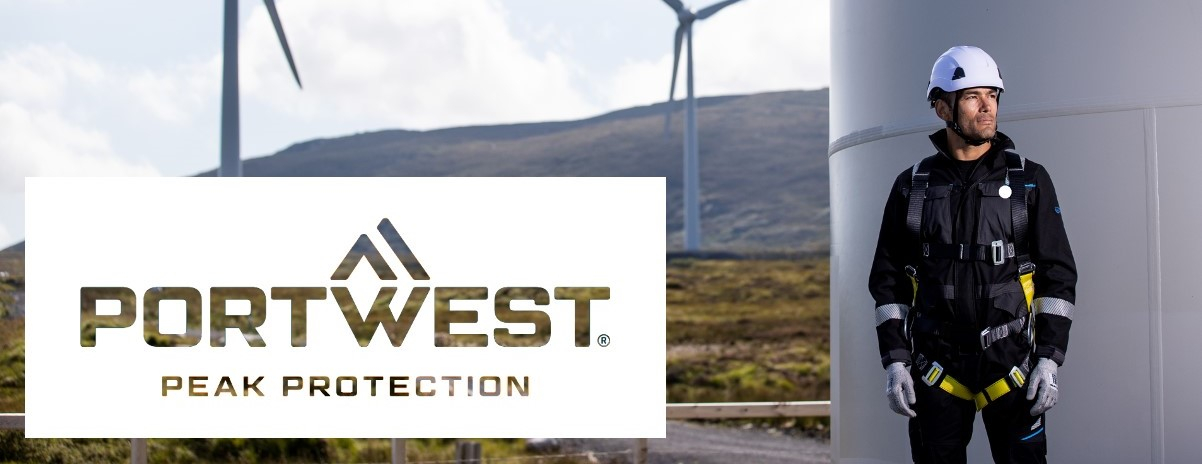 A worker wearing full fall protection equipment is standing next to a wind turbine. More wind turbines can be seen in the background. The Portwest logo with the slogan 'Peak Protection' is displayed in the foreground.