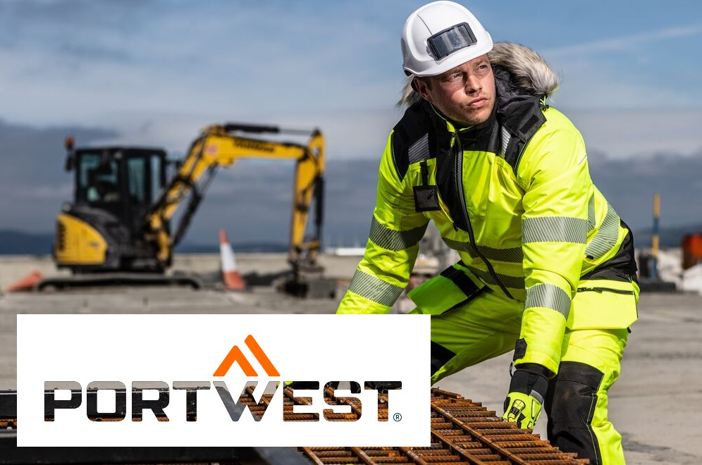 Worker in yellow winter clothing and white helmet lifting an iron grate. In the background you can see an excavator, a mountain range and blue sky. In the bottom left of the picture you can see the Portwest logo against a white background. A link to our winter jackets is provided.