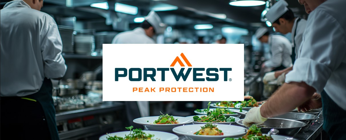 A commercial kitchen with several chefs in white chef's clothing working at different stations and arranging food on plates. In the foreground, the focus is on freshly prepared dishes. The Portwest "Peak Protection" logo is placed centrally above the picture.