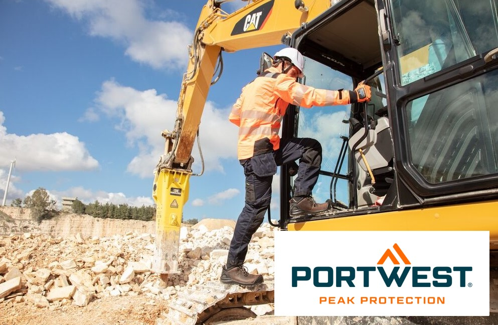 A worker in orange protective clothing and a white helmet climbs into the cabin of a yellow excavator on a construction site. In the background you can see a clear blue sky and a quarry. In the bottom right of the picture you can see the logo of "Portwest Peak Protection". There is a link to our selection of gloves.