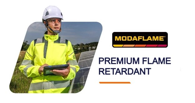 Woman in high visibility yellow protective clothing and white helmet holding a tablet and standing in front of a meadow and solar panels. Next to her is the Modaflame logo and the headline Premium Inherent Flame Retardant. A link to the Modaflame collection is provided.